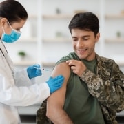 Soldado recibiendo un disparo de una profesional médica