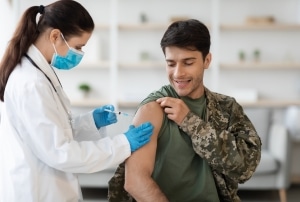 Soldier receiving a shot from a female medical professional