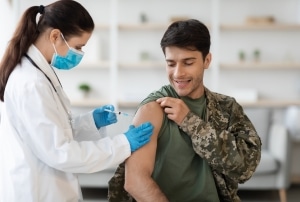 Soldado recibiendo un disparo de una profesional médica