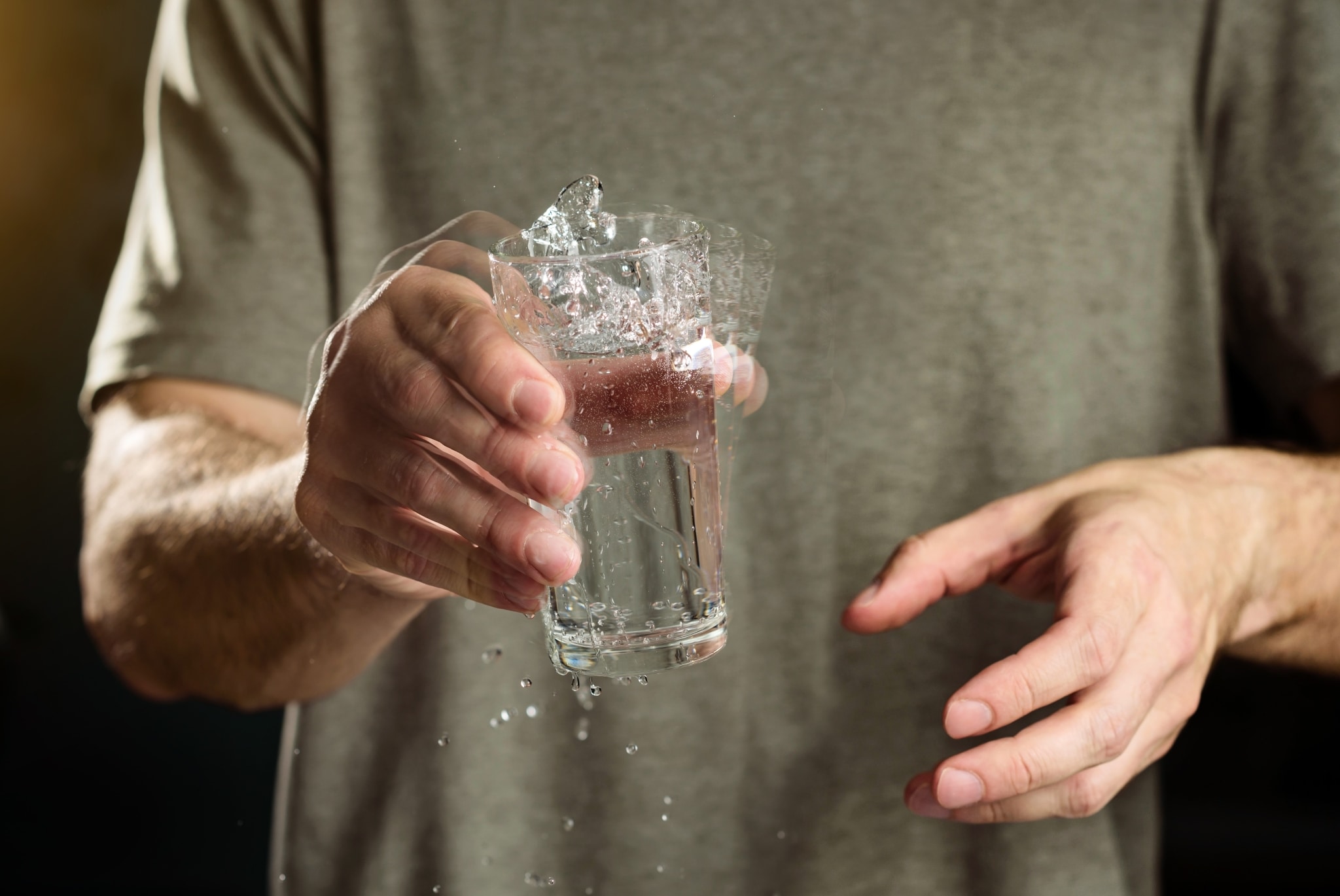 Man with Parkinson's Disease holding a shaking glass of water