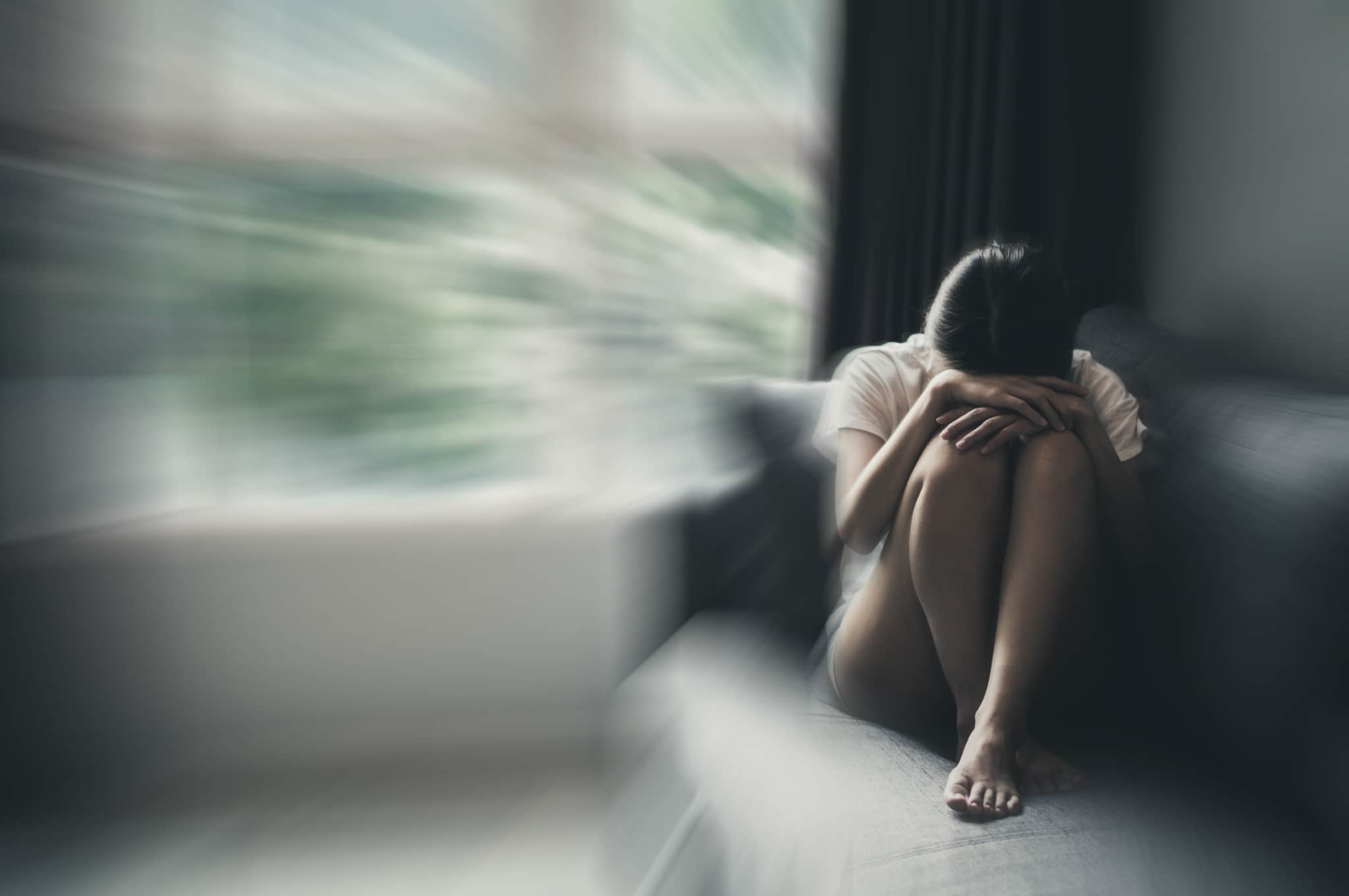 Blurred woman resting her head on her knees