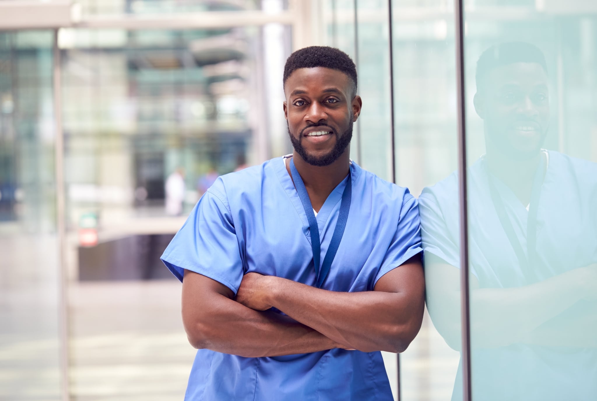 Male African-American nurse leaning against a wall