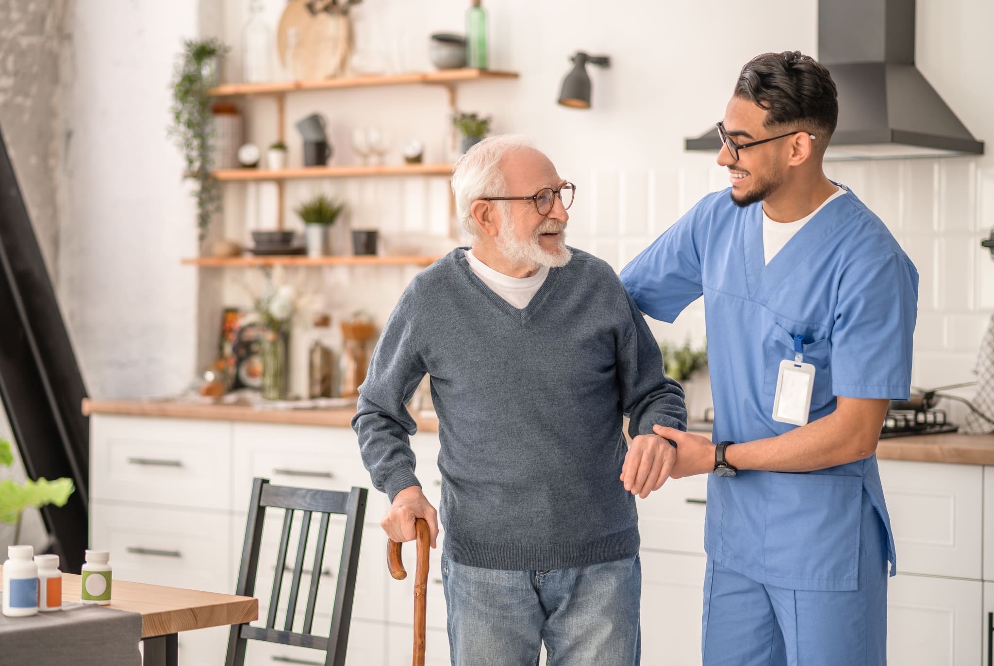 Male nurse helping an elderly man with a cane