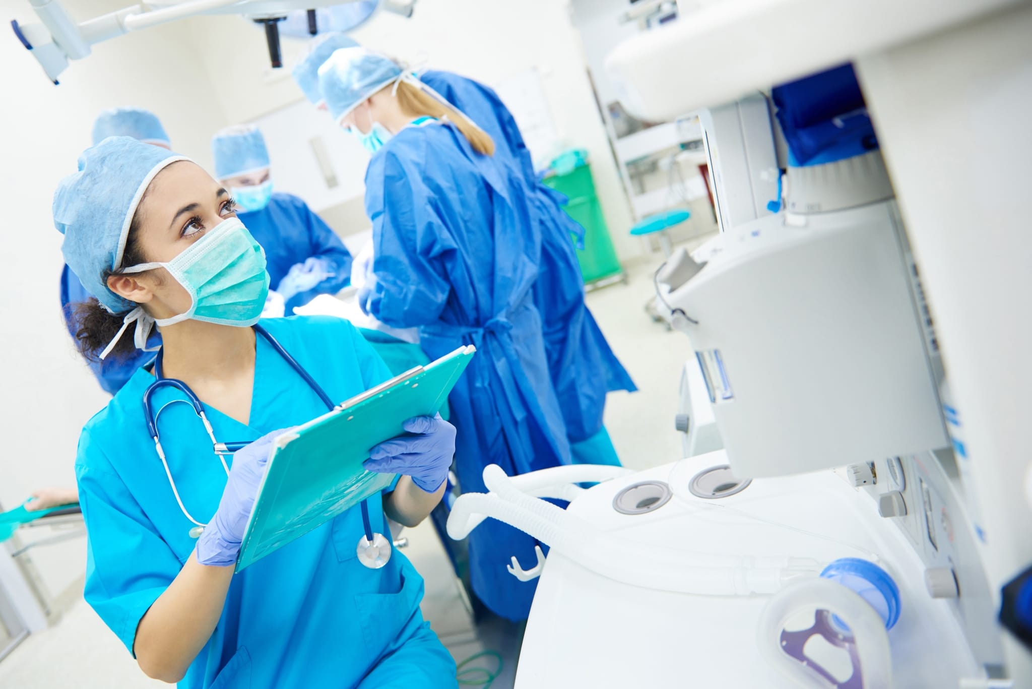 Surgical Technologist writing on a clipboard in the OR