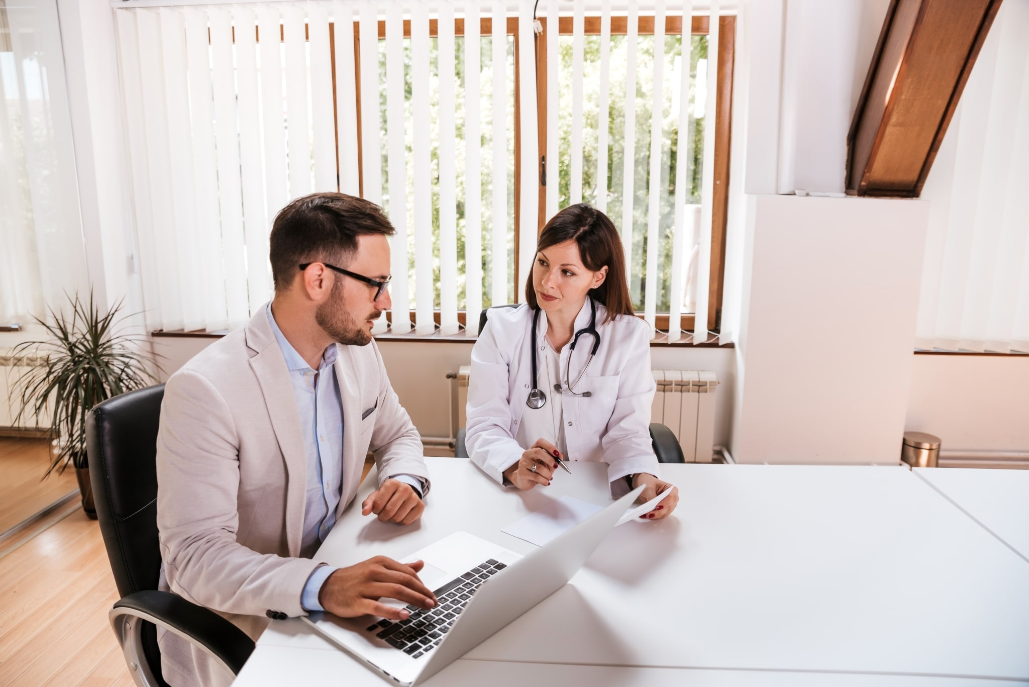 Medical professional speaking with a man in a conference room