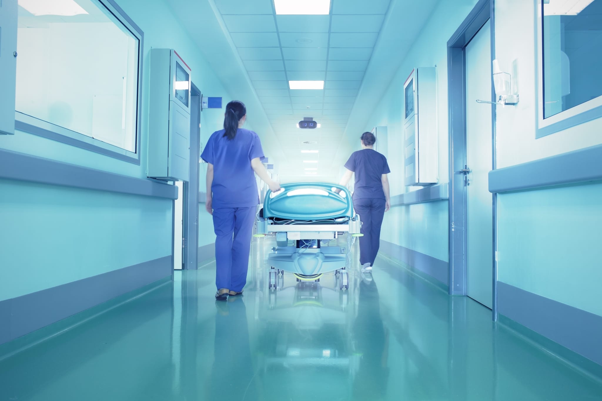 Enfermeras transportando a un paciente en el pasillo de un hospital