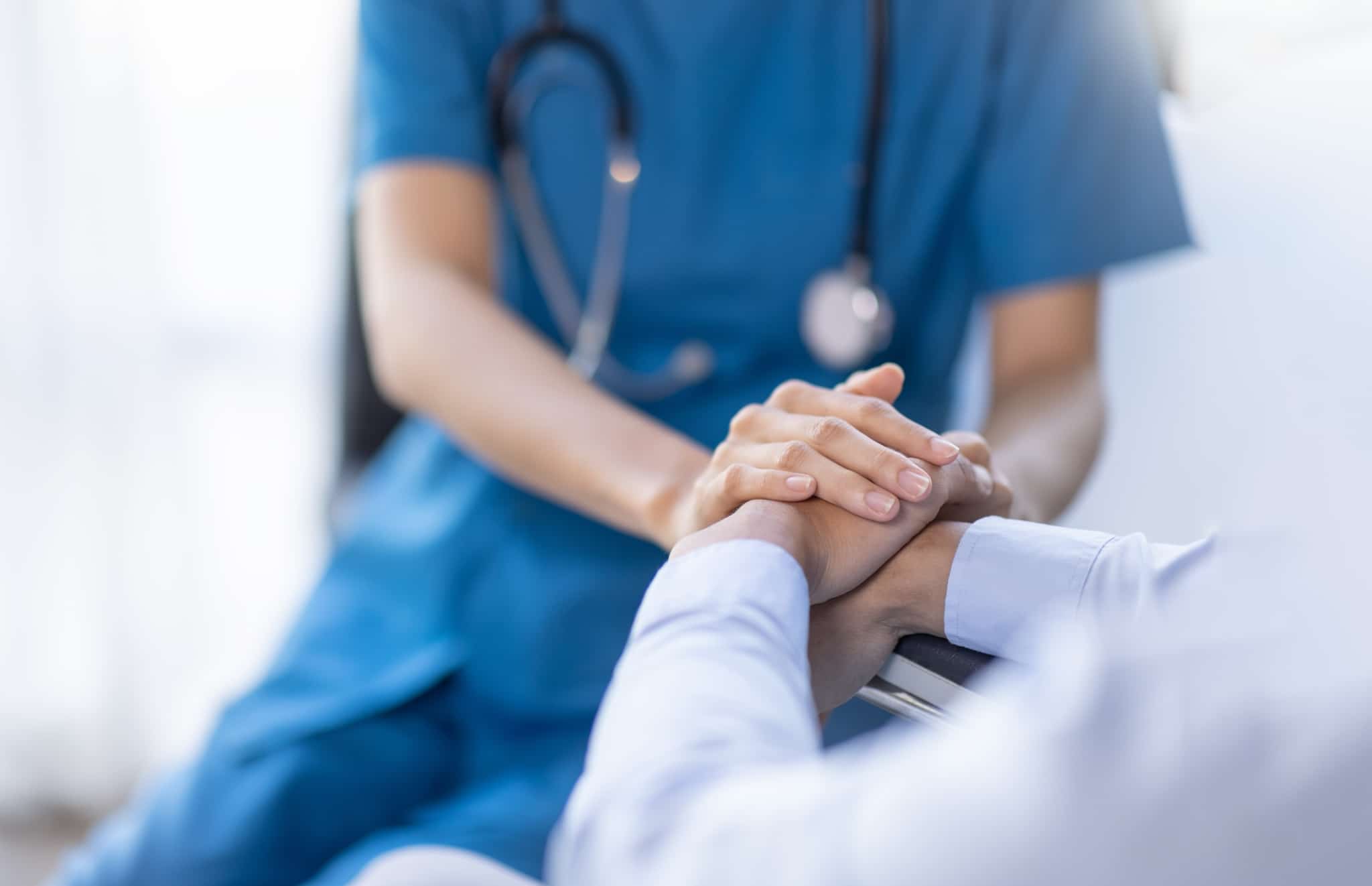 Close up of a nurse consoling a patient