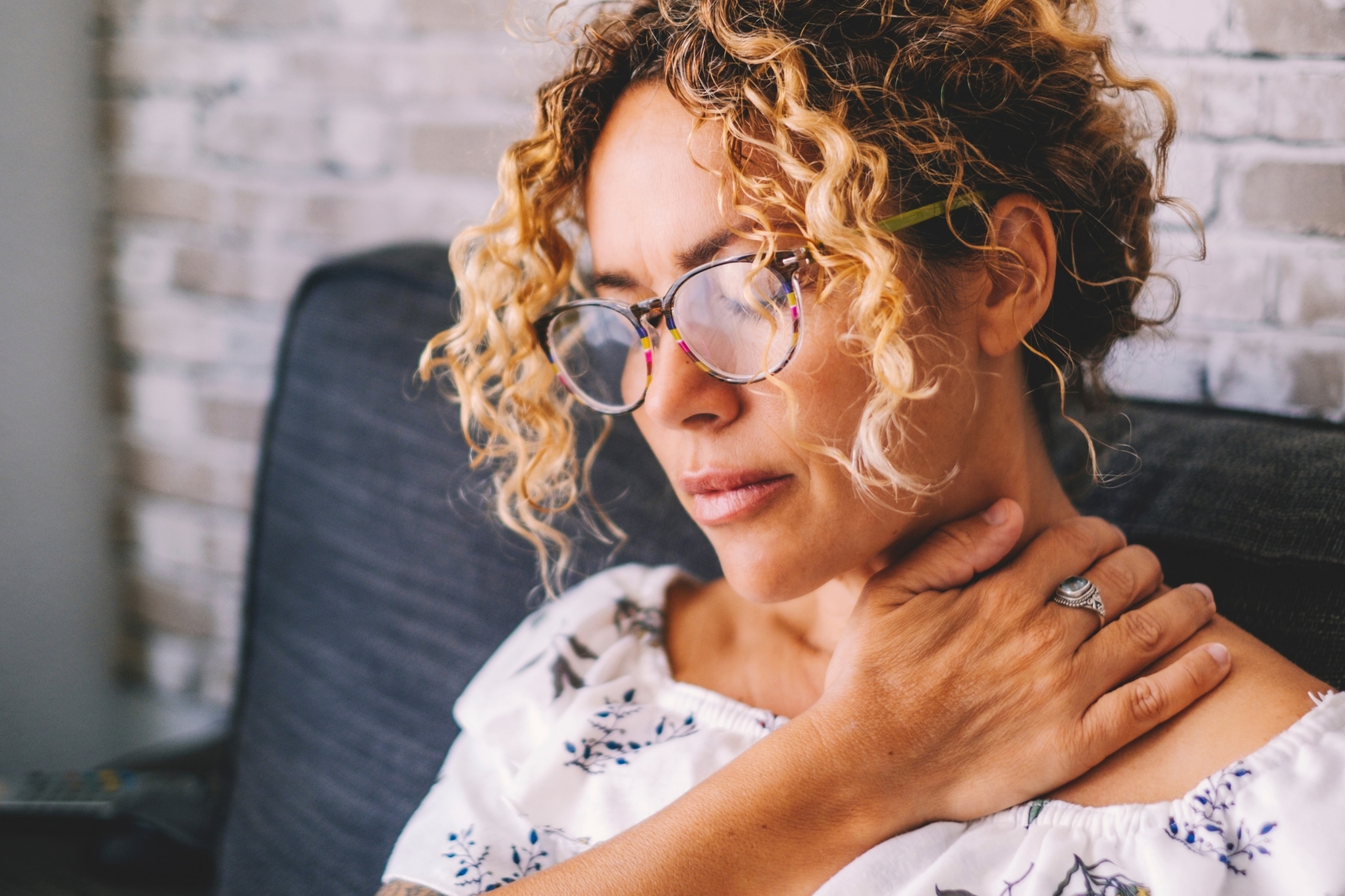 African-American woman touching her neck and shoulder in pain