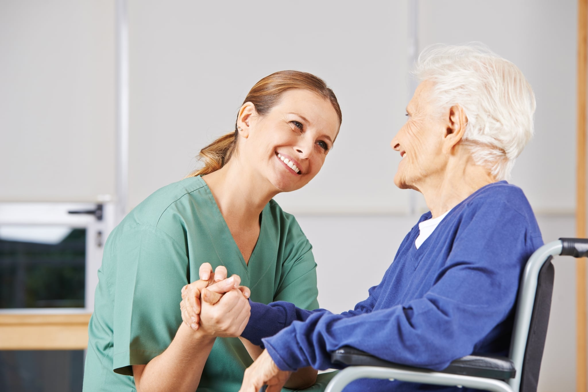 Female nurse holding the hand of an elderly patient