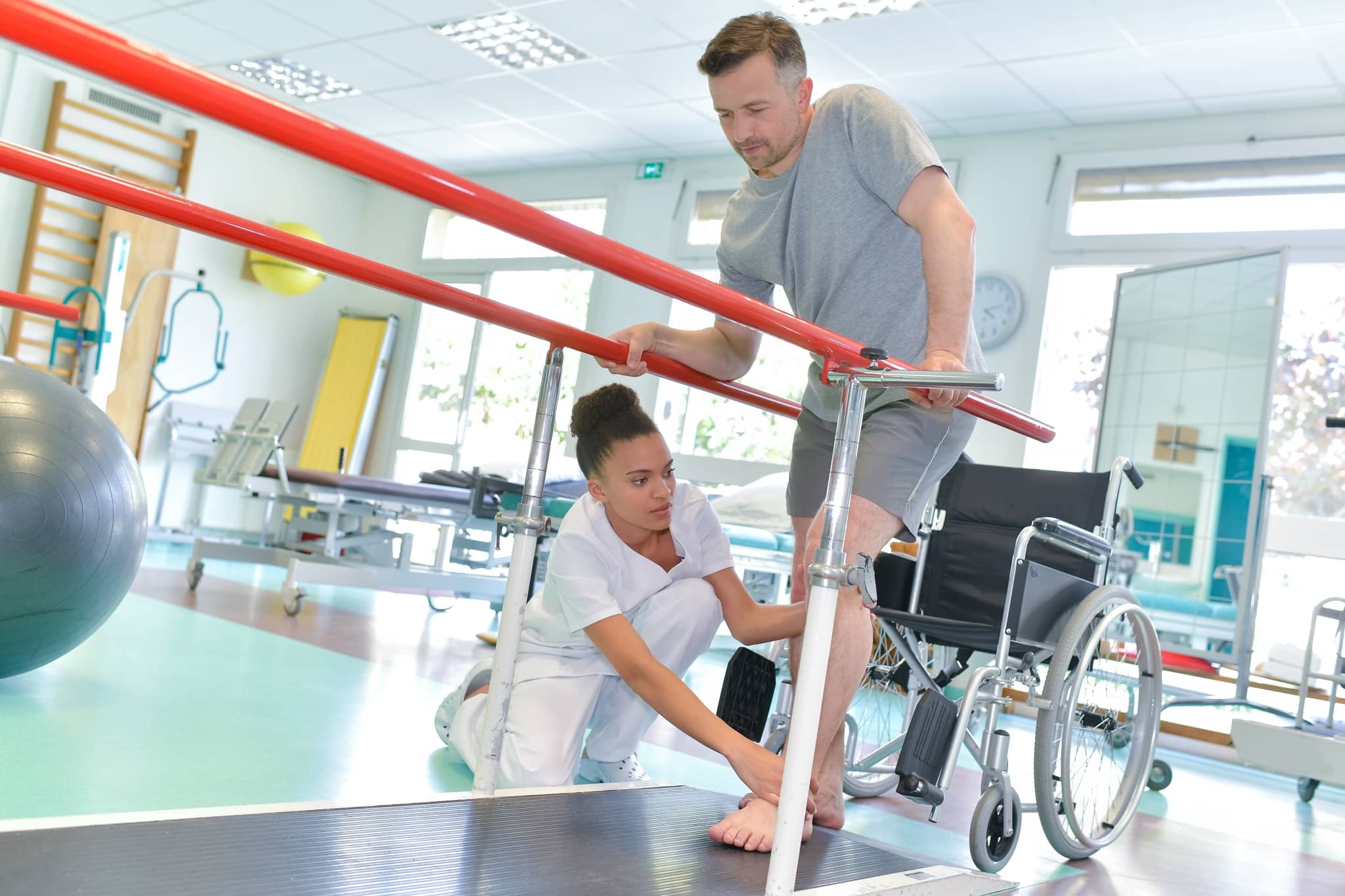 Occupational therapy professional helping a man in a wheelchair perform exercises