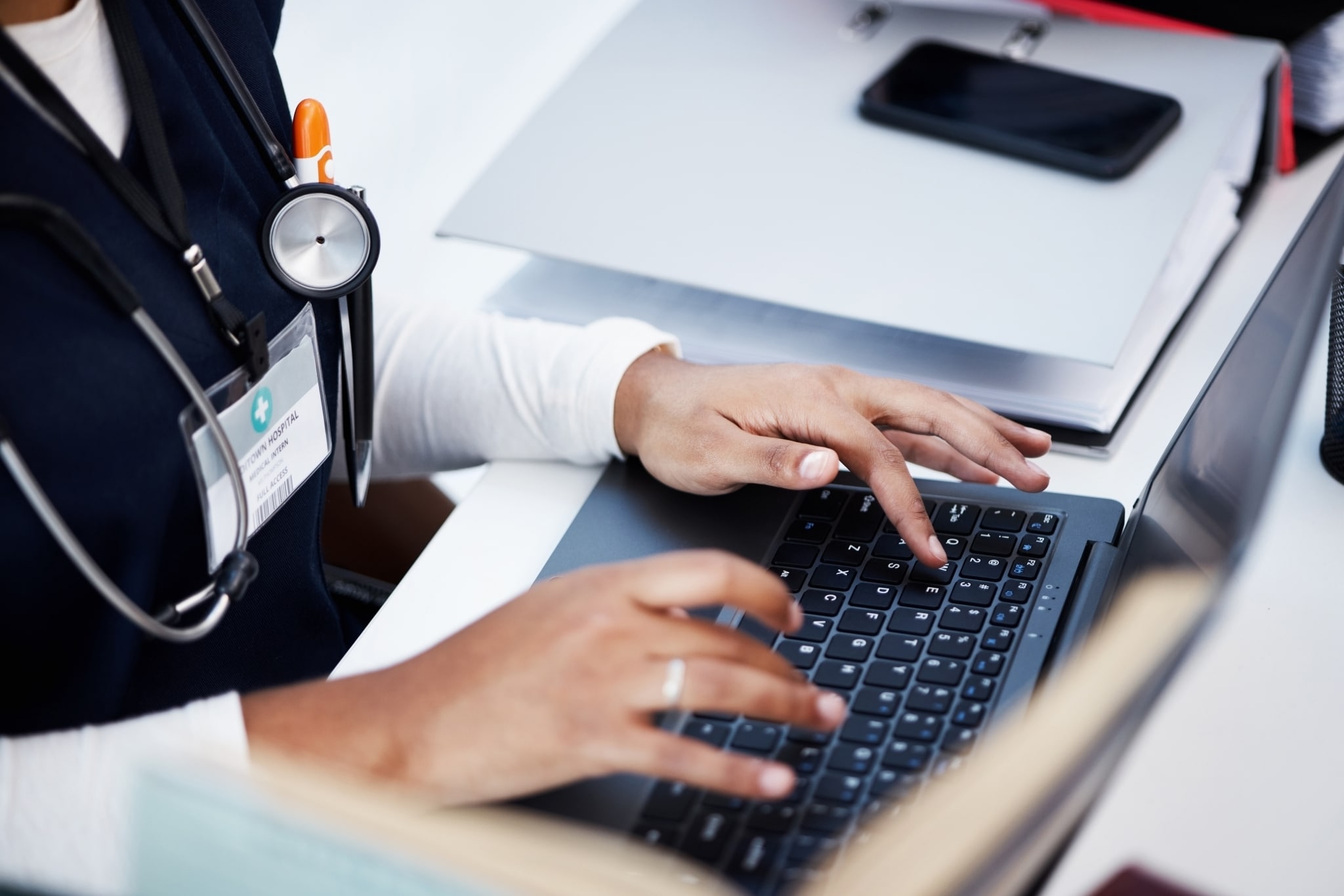 Close up of a medical professional typing on a laptop