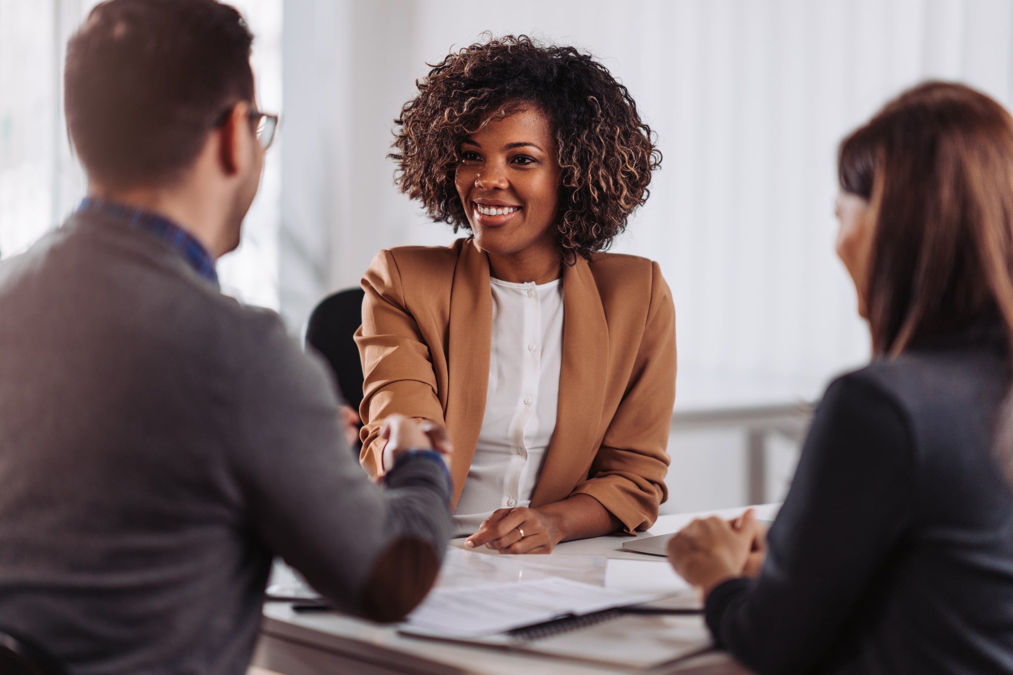 African-American business professional shaking hands with interviewers