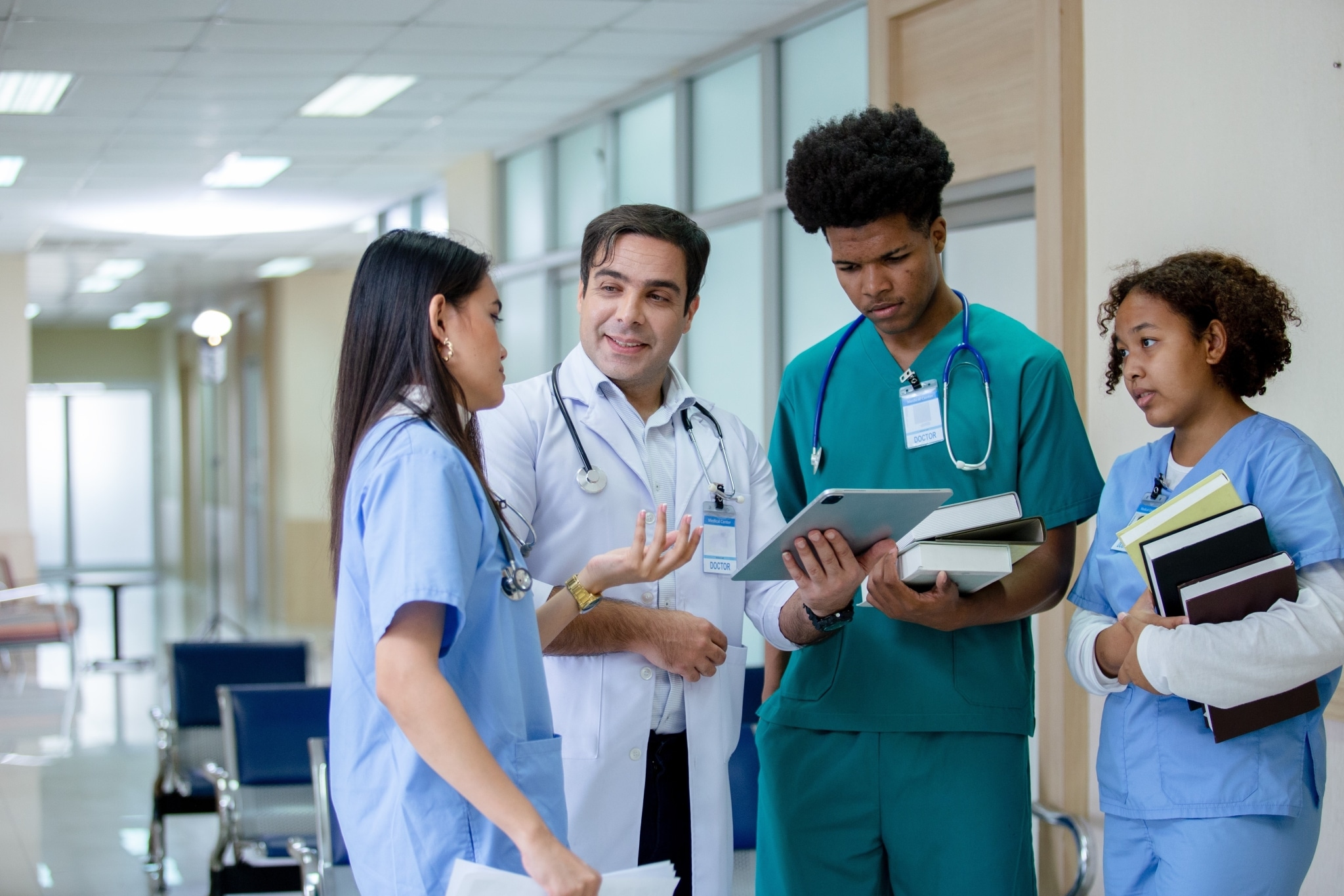 Medical instructor and students standing in a hospital hallway