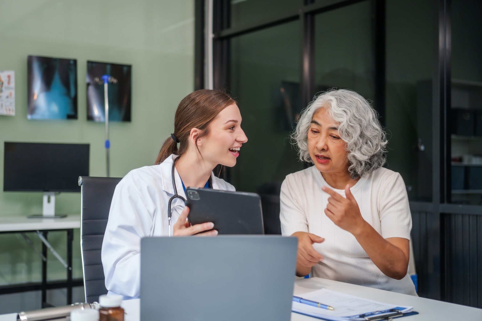 Female healthcare professional speaking with an elderly patient