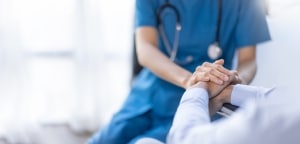 Close up of a medical professional consoling a patient