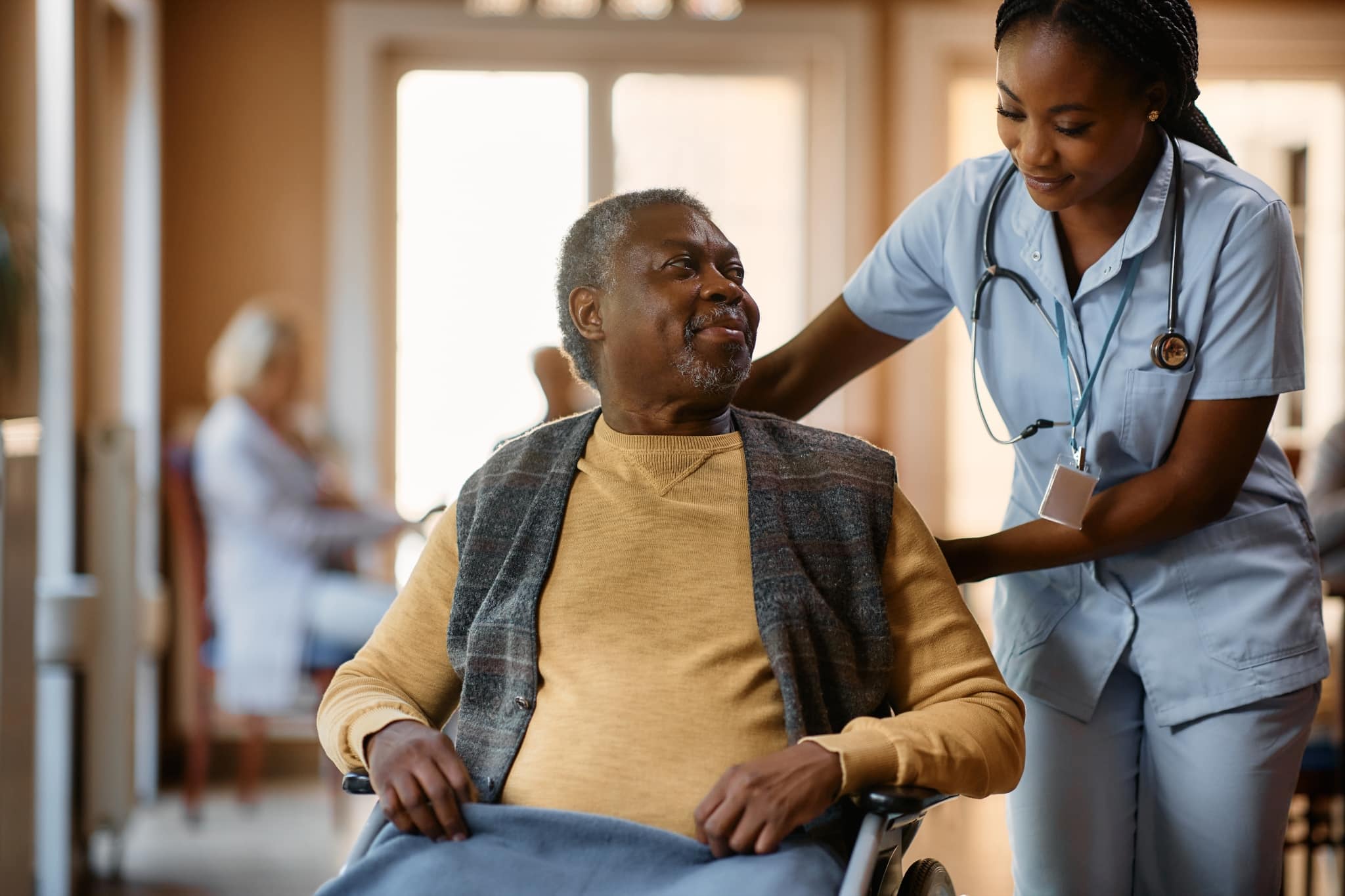 African-American medical professional helping a man in a wheelchair