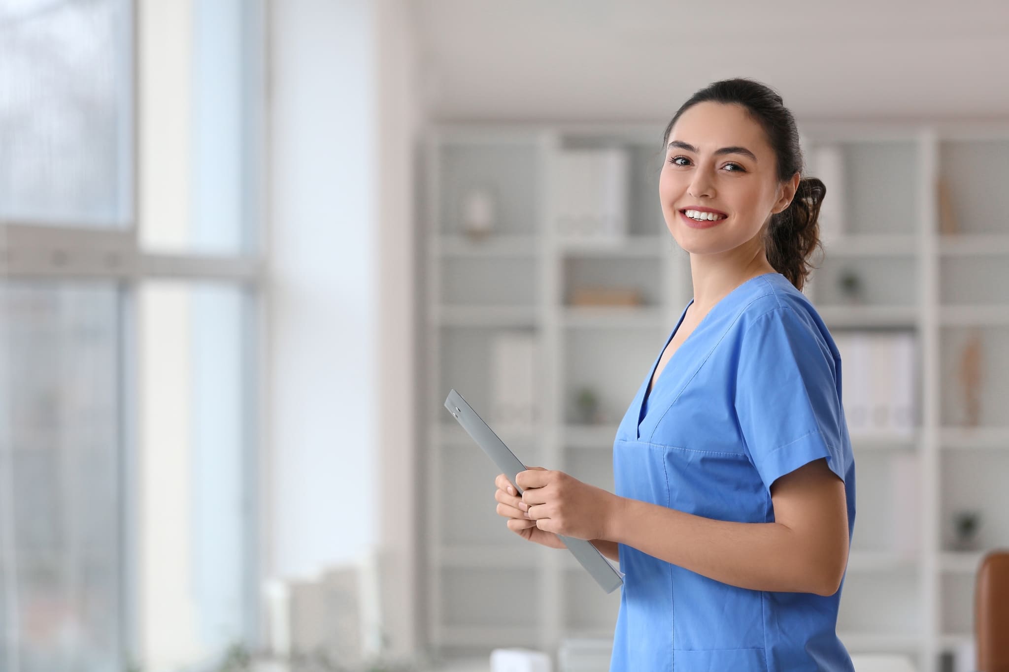 Smiling medical professional standing by a window