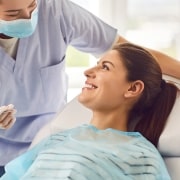 Young Dental Assistant with a smiling female patient