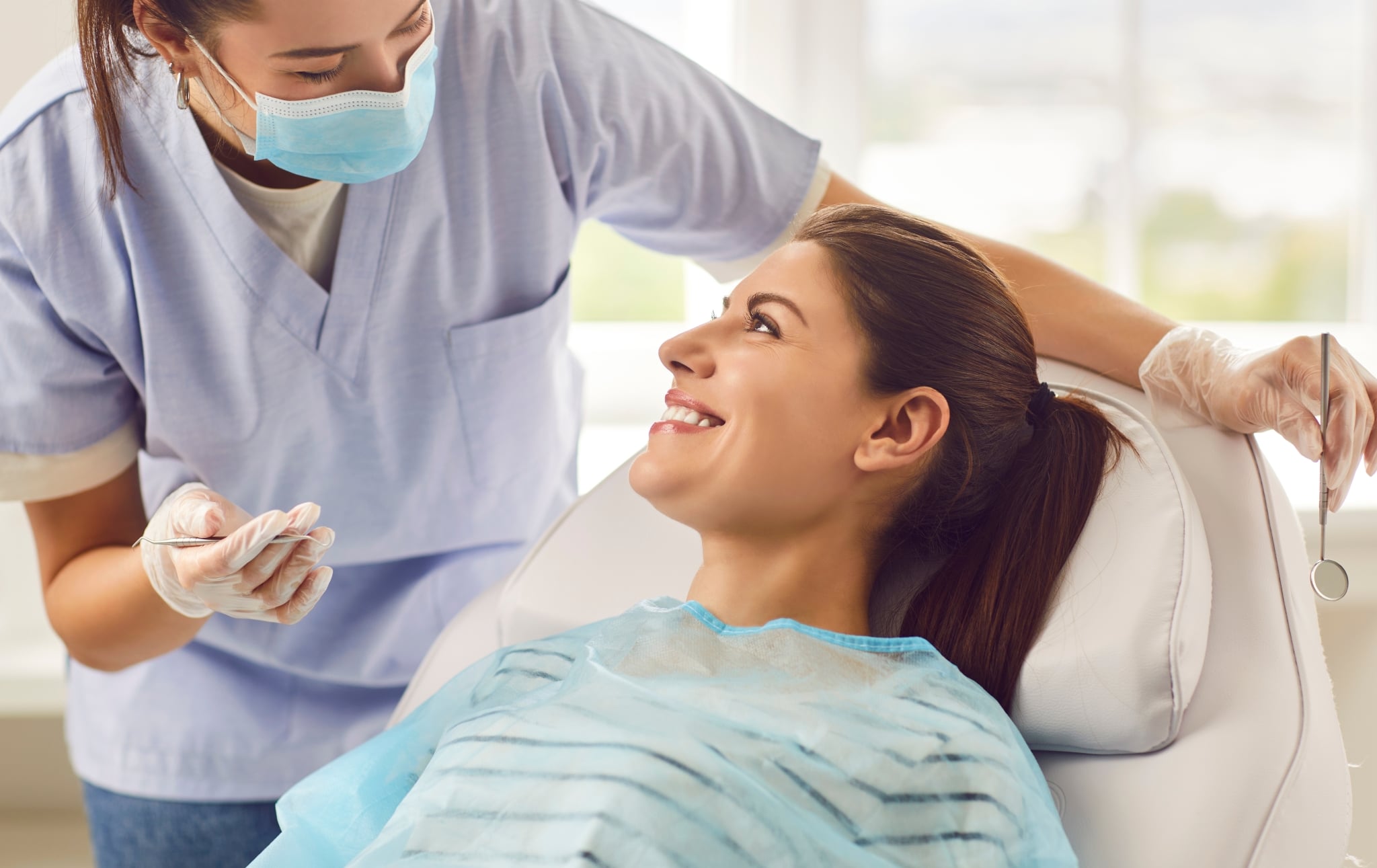 Young Dental Assistant with a smiling female patient
