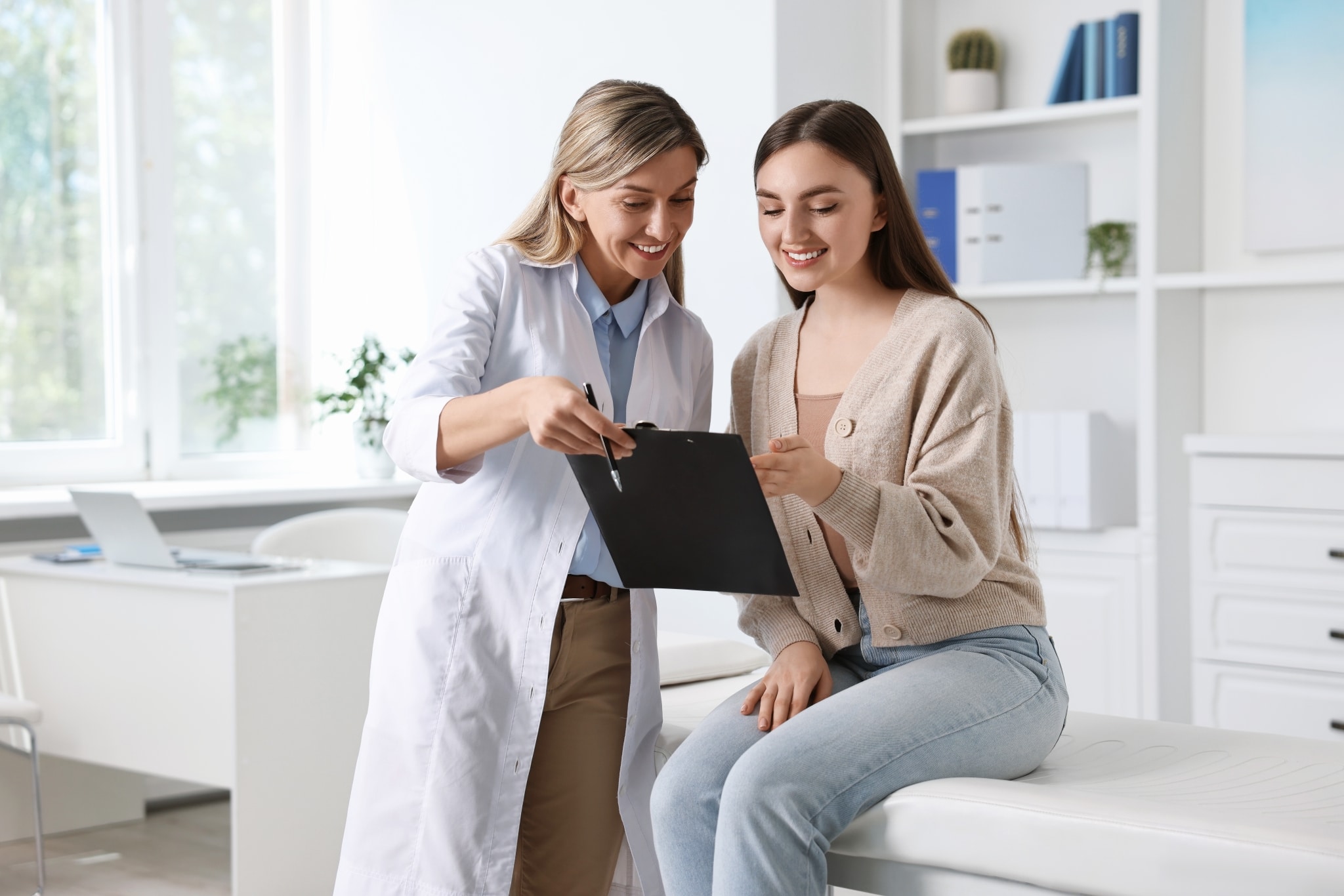 Doctor working with a female patient in an exam room