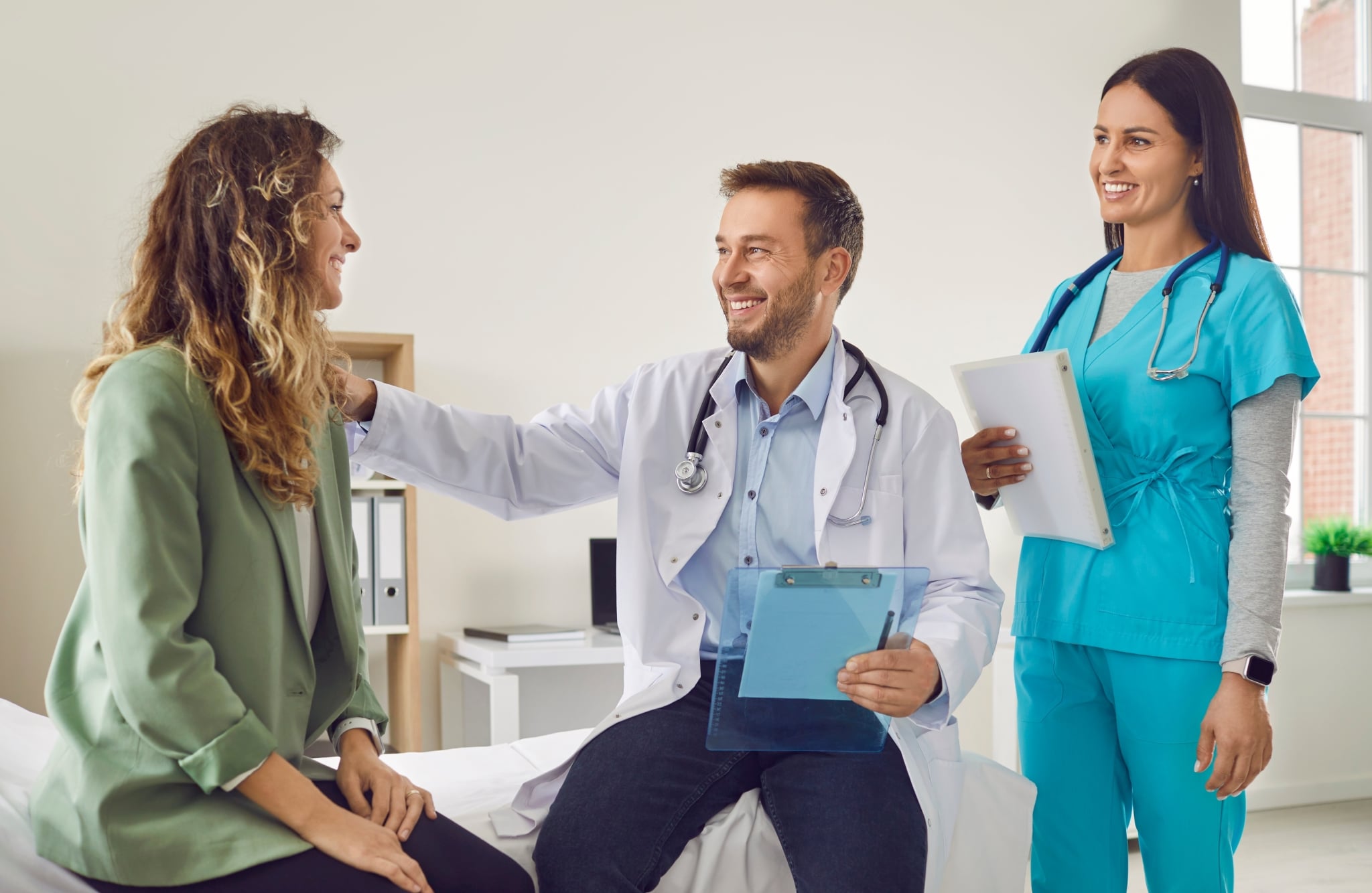 Smiling medical professionals speaking with a patient
