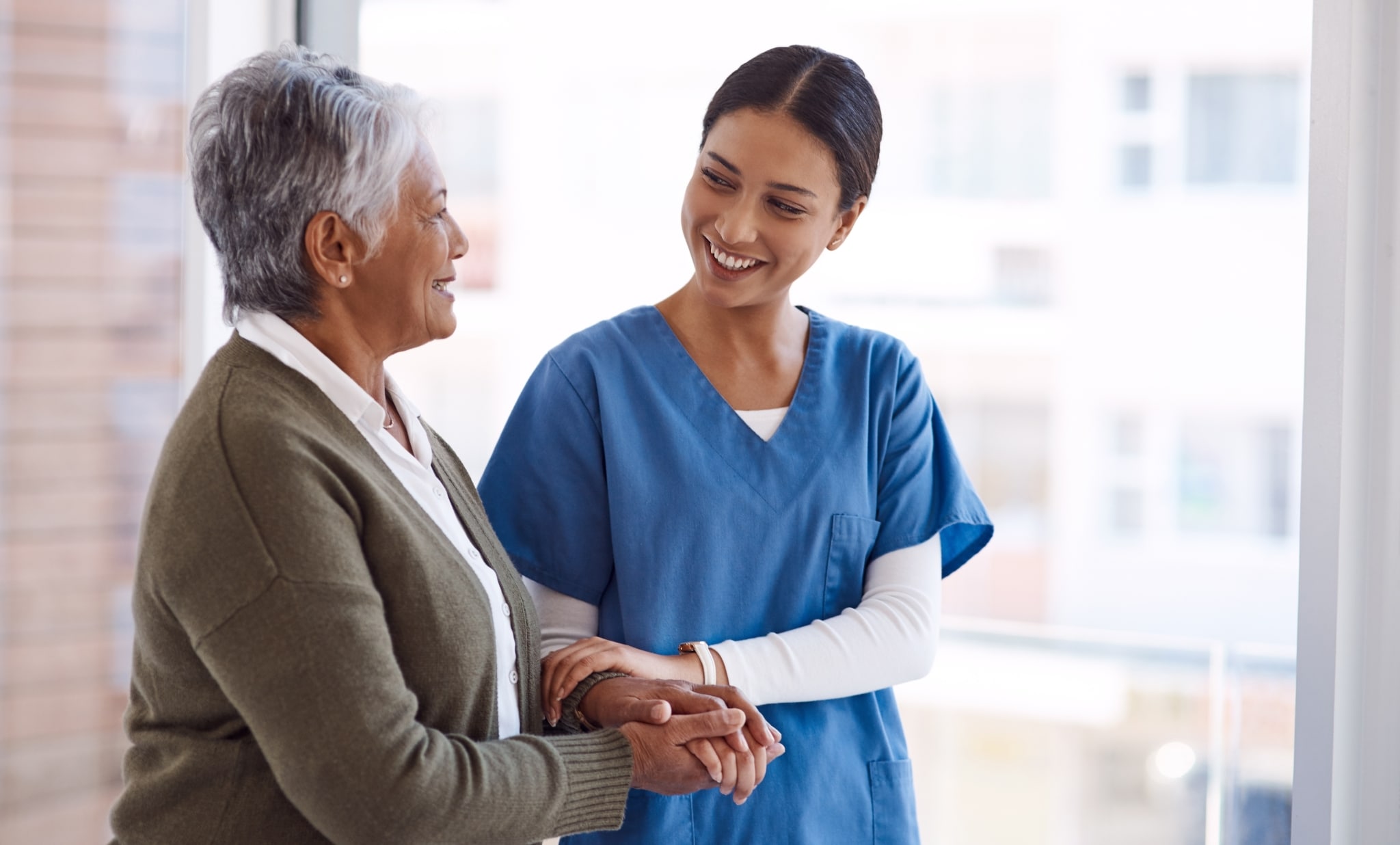 Smiling nurse escorting a senior patient