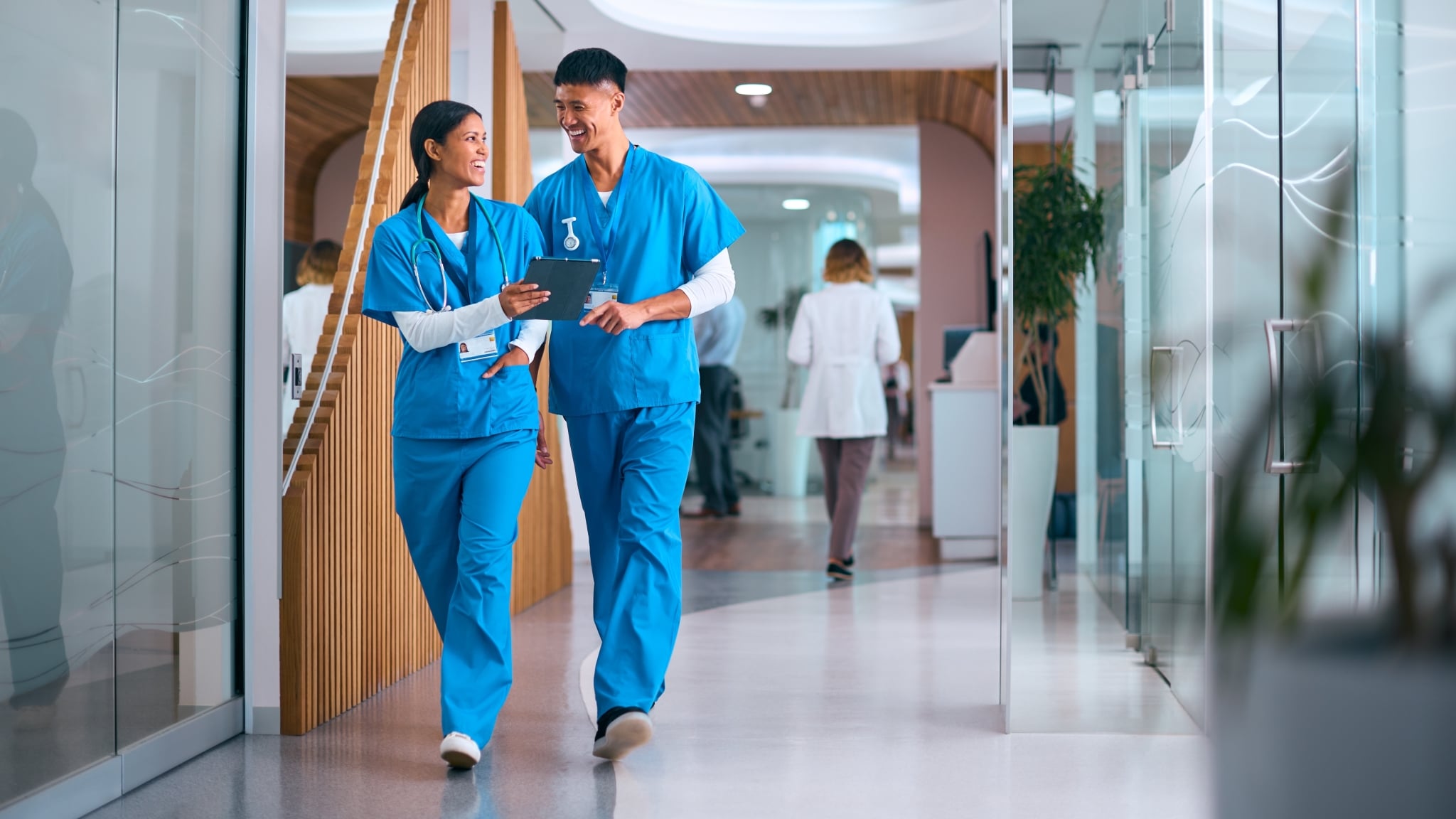 Male and female medical professionals walking in a hallway