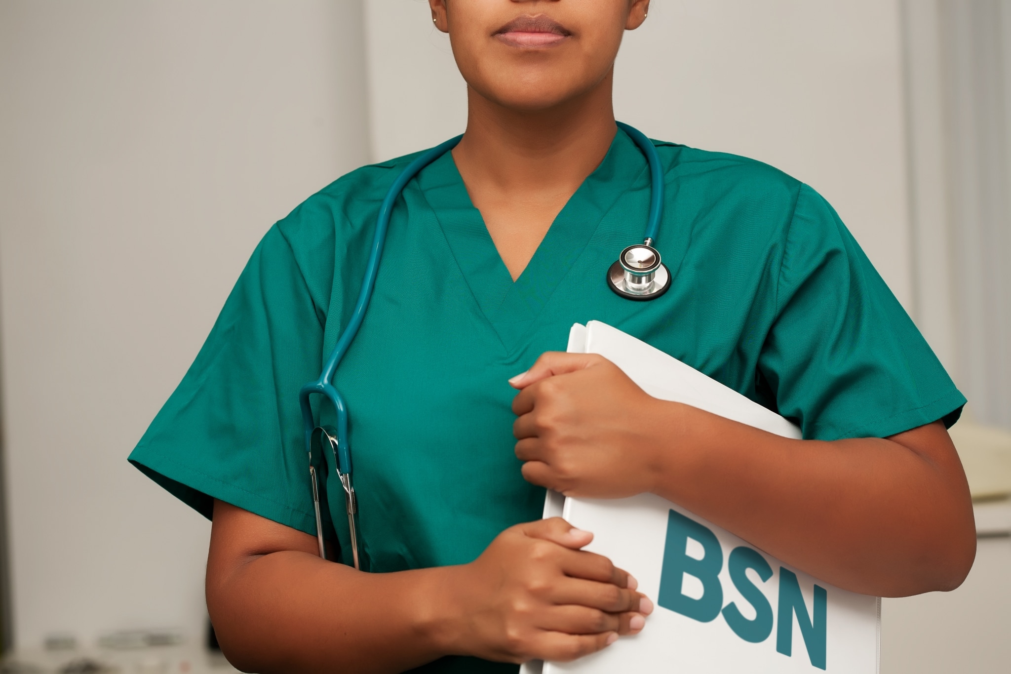 Close up of an African-American nurse holding a binder that says BSN