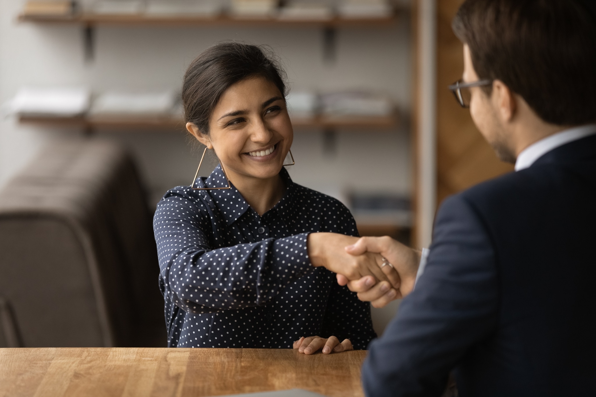 Female professional shaking hands with a man at a staffing agency