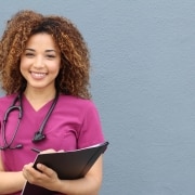Smiling African-American nurse in pink scrubs